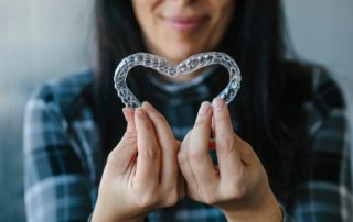Patient Making Heart-Shape with Dental Aligners